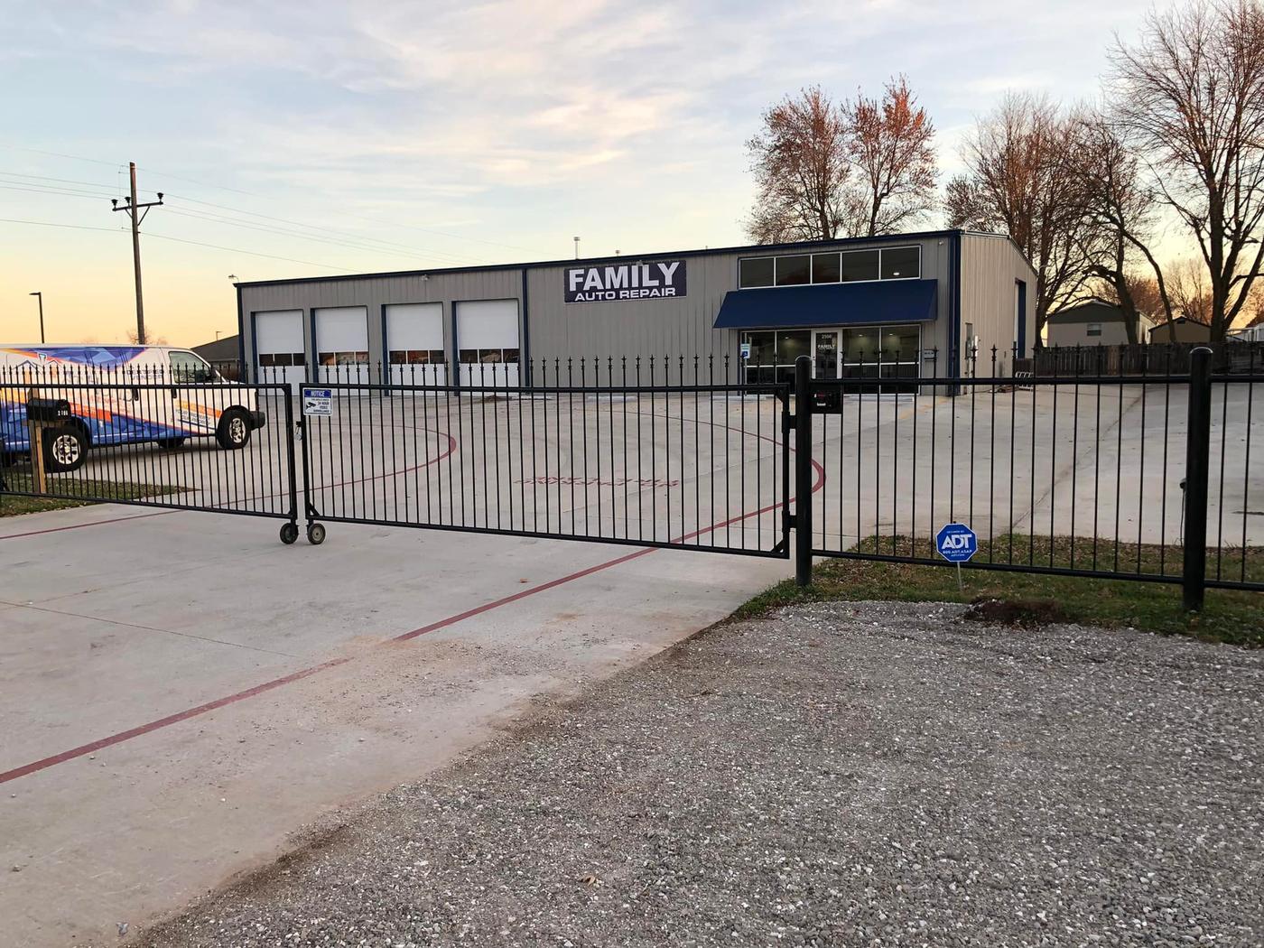 The Family Auto Repair building at dusk, with its sign above four bay doors and a navy awning over the office entrance